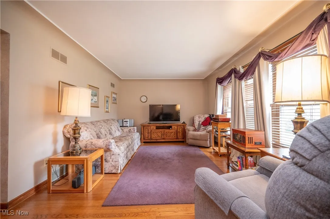 Living room with wood finished floors and molding