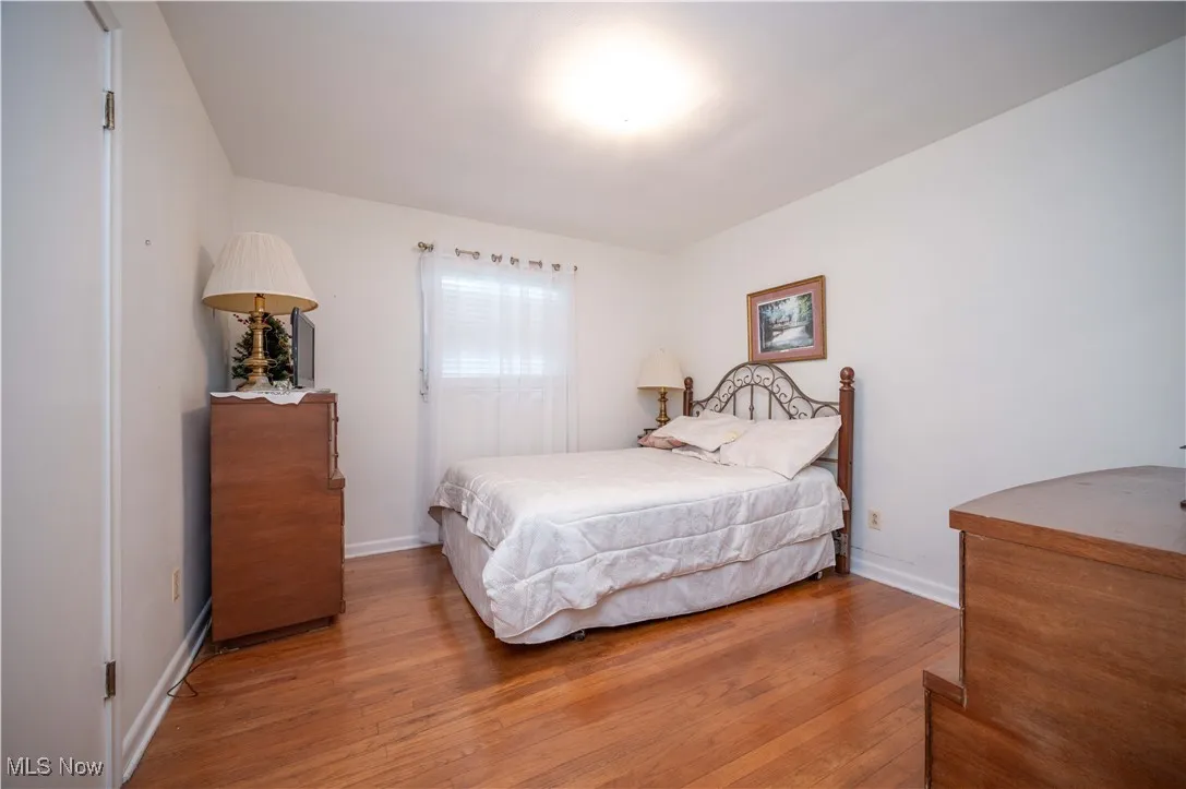 Bedroom with wood finished floors and baseboards