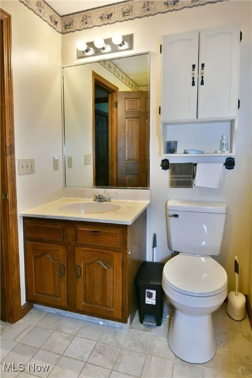 Half bathroom with vanity and toilet