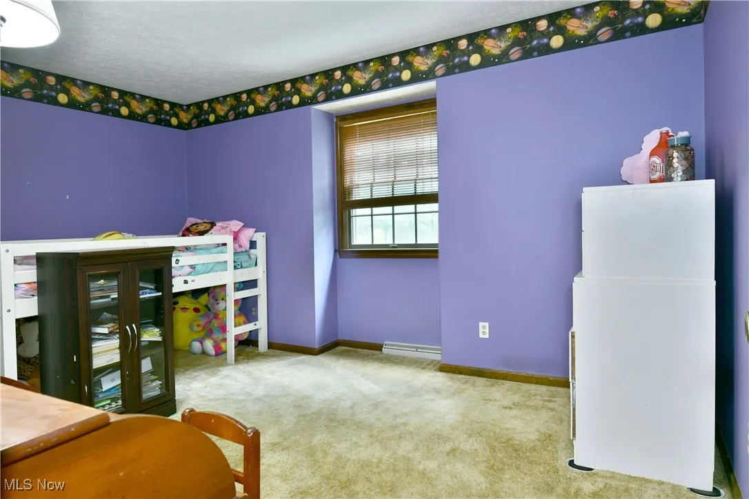 Bedroom with carpet floors and a baseboard radiator