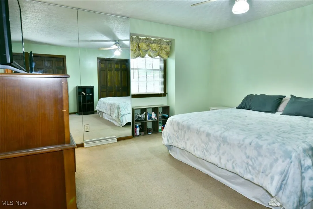 Bedroom featuring carpet, a textured ceiling, and a ceiling fan