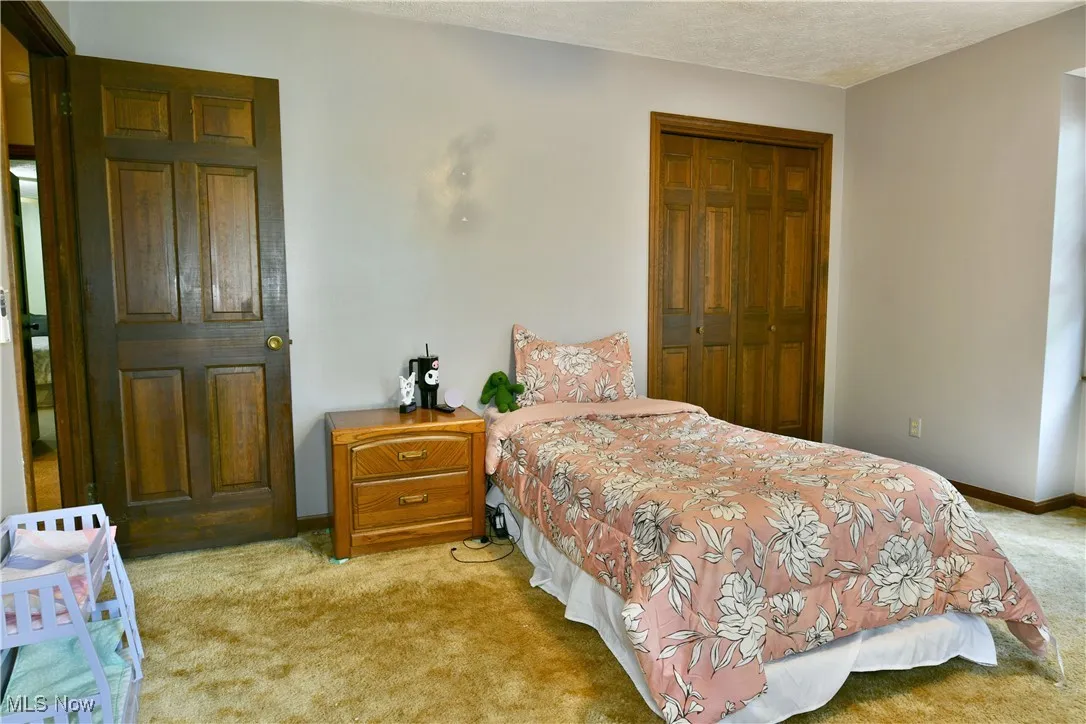 Bedroom featuring light carpet and a closet