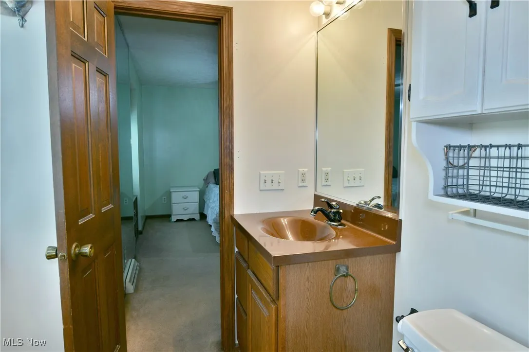 Half bath with vanity and baseboard heating