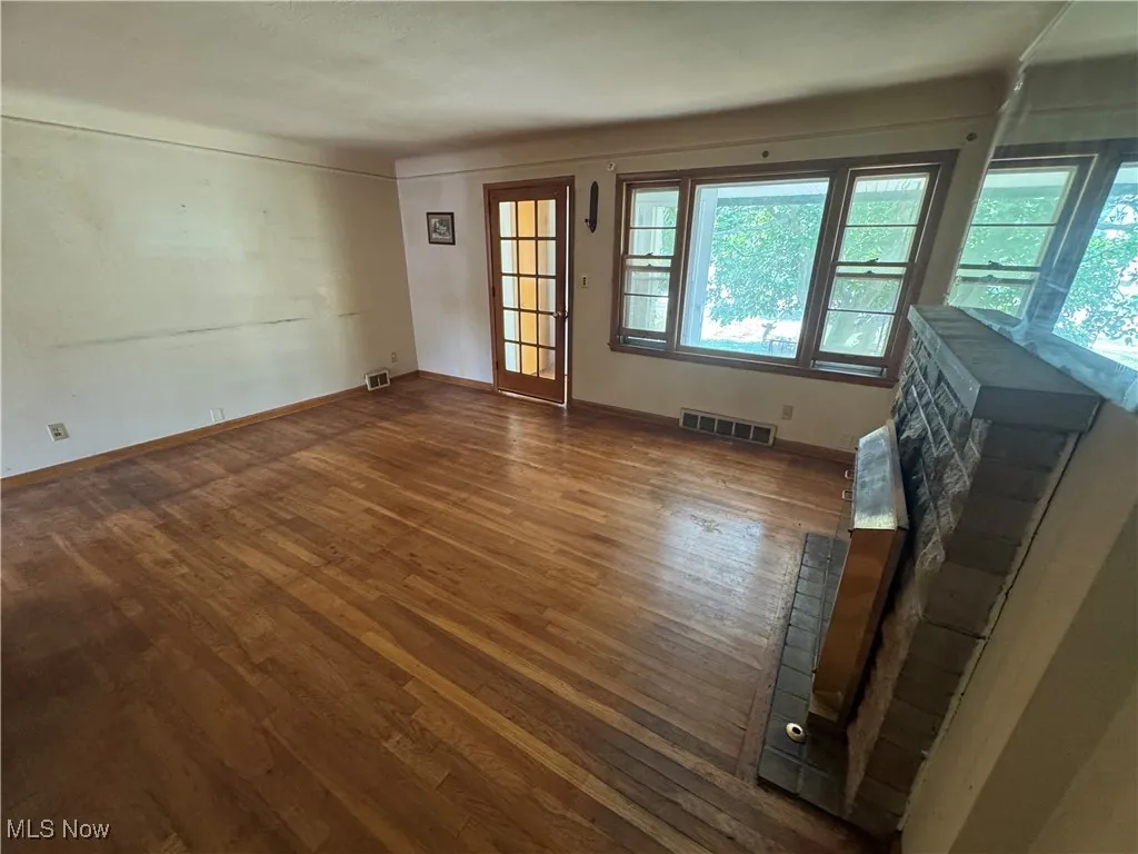 Unfurnished living room with wood finished floors and plenty of natural light