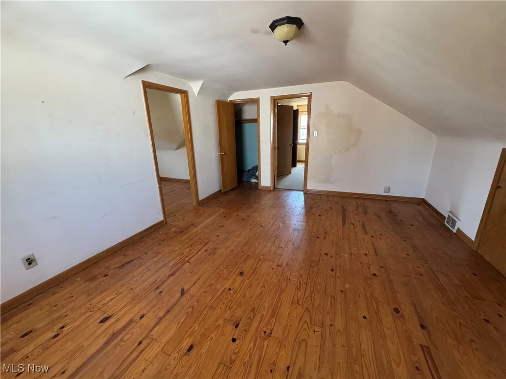 Bonus room featuring lofted ceiling and wood-type flooring