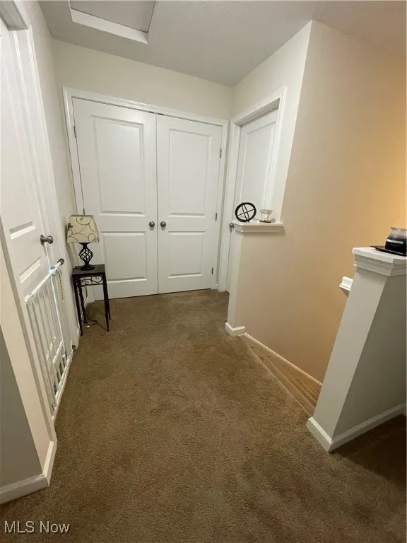 Hall with an upstairs landing and carpet floors