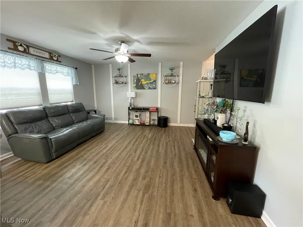 Living area featuring light wood-style floors and a ceiling fan
