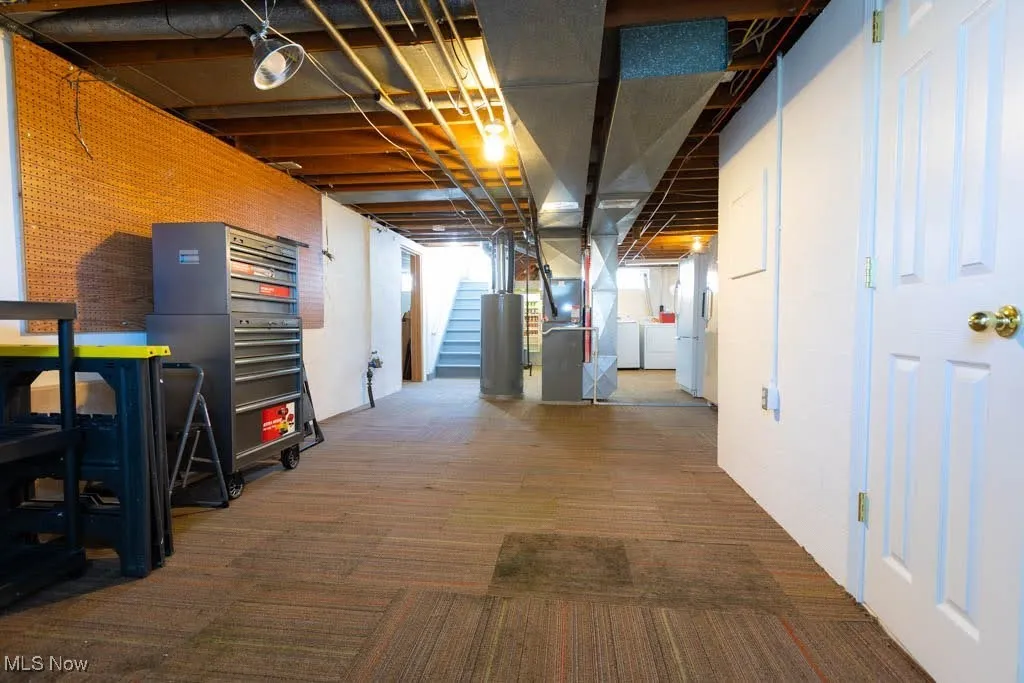 Basement featuring independent washer and dryer, carpet flooring, stairway, and heating unit