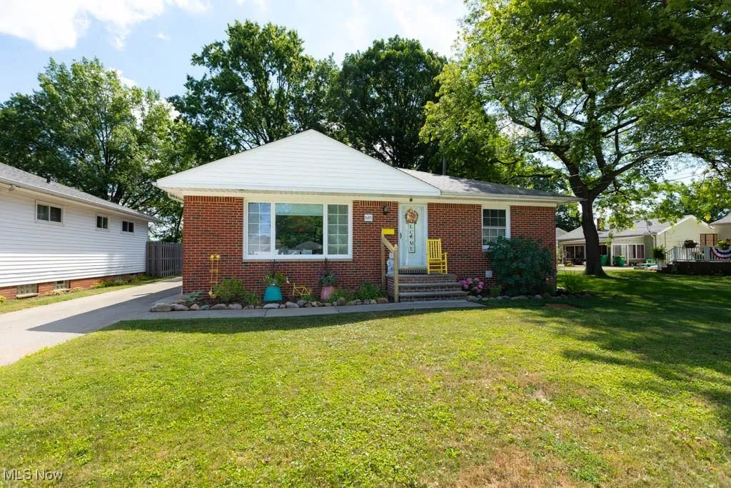View of front of property with brick siding and a front lawn