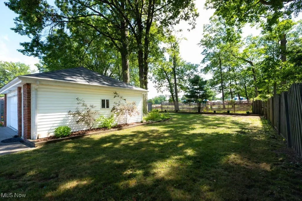 Fenced backyard featuring an outbuilding and a garage
