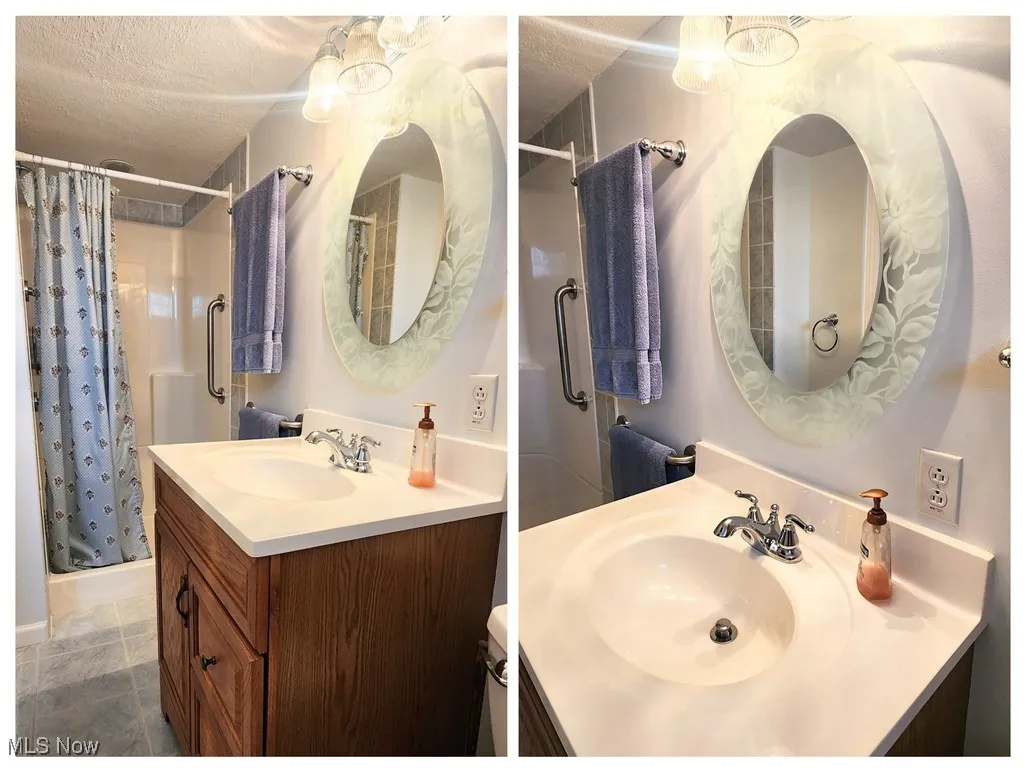Full bathroom with a stall shower, vanity, IN LOWER LEVELand a textured ceiling