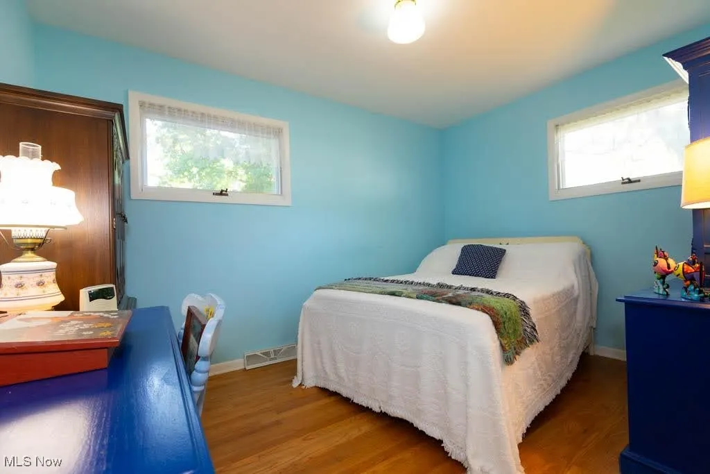 Bedroom featuring wood finished floors and baseboards