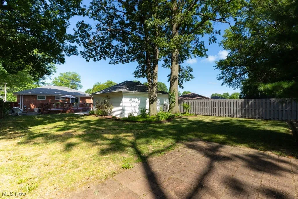 Fenced backyard with a wooden deck and an outdoor structure