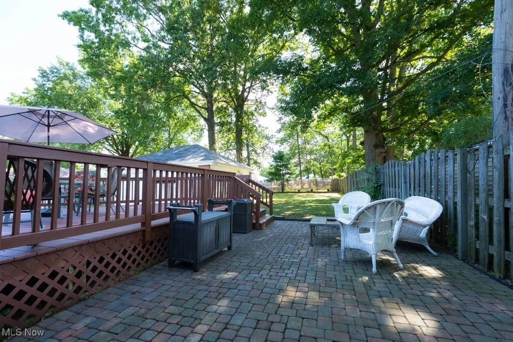 Fenced backyard featuring a patio area and a wooden deck