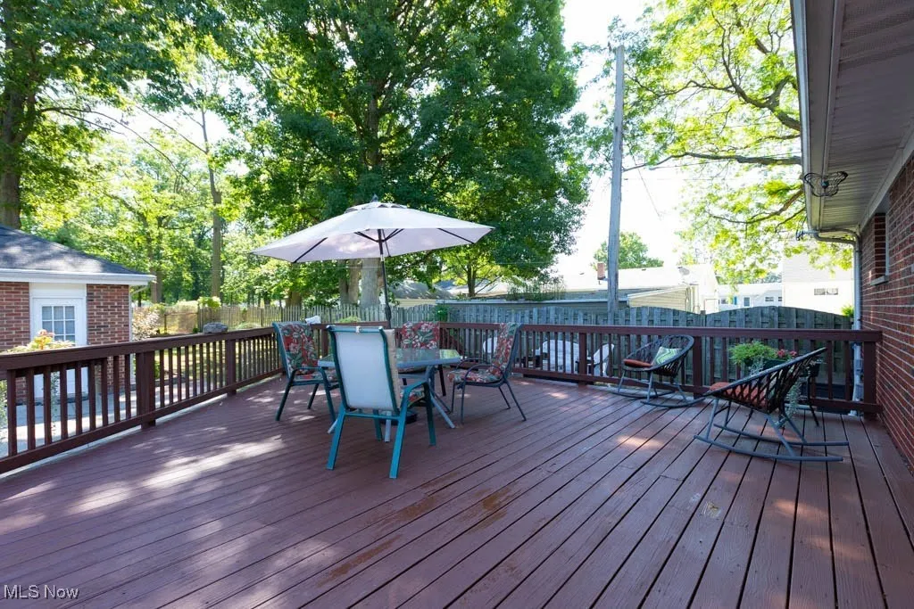Wooden deck with a fenced backyard and outdoor dining area