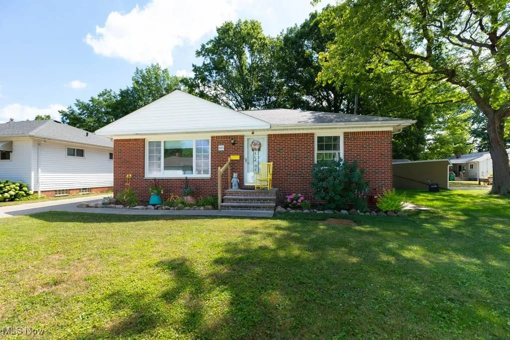 Ranch-style house with a front yard and brick siding