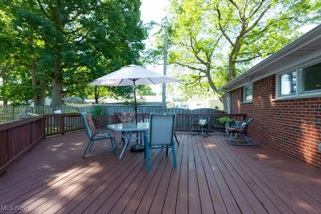 Wooden terrace with a fenced backyard and outdoor dining space