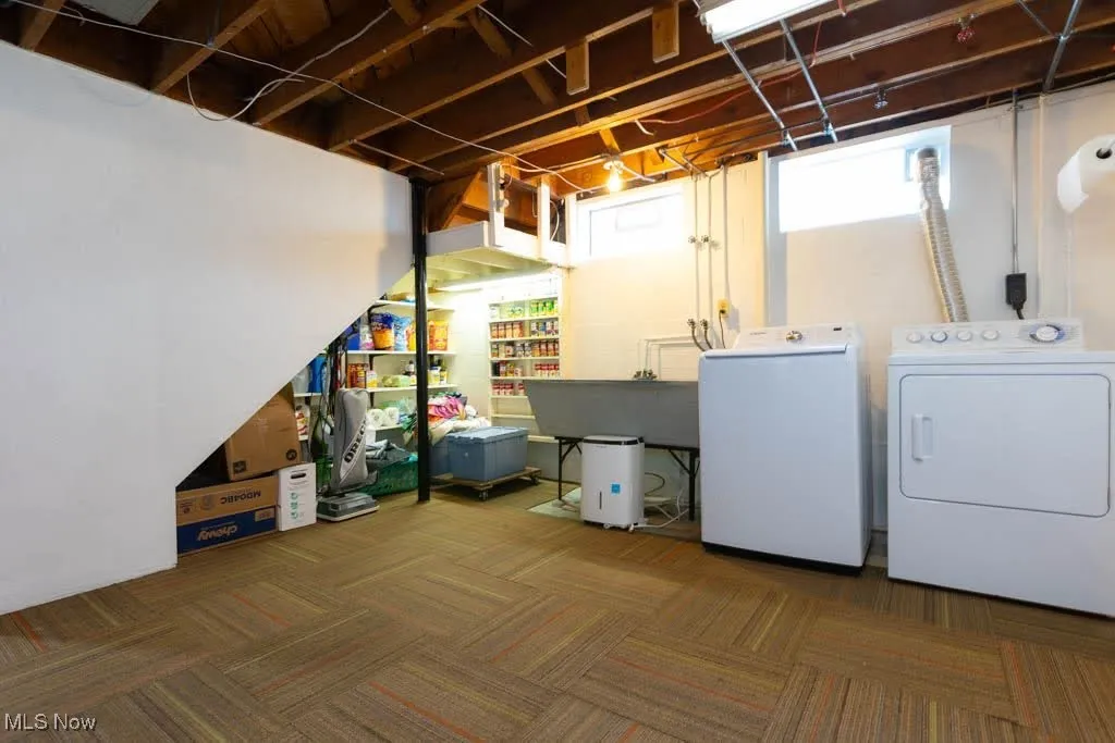 Below grade area with separate washer and dryer and carpet floors