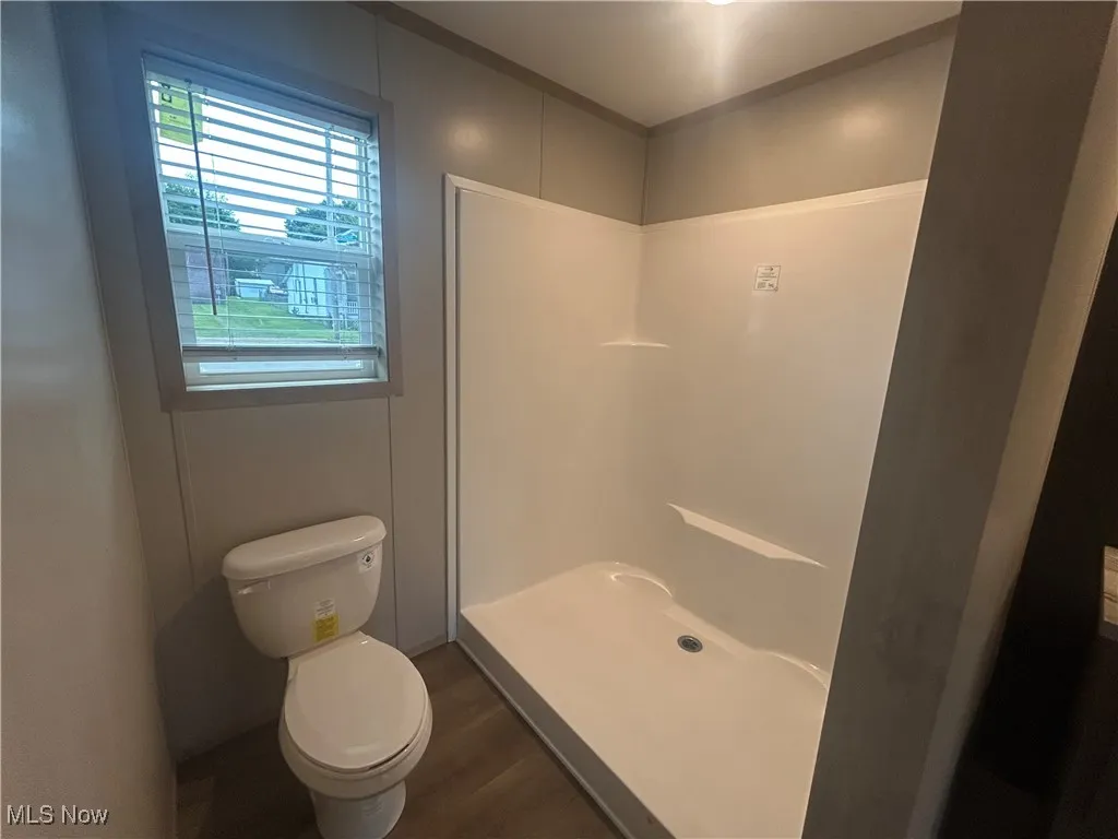 Bathroom with wood finished floors and a stall shower