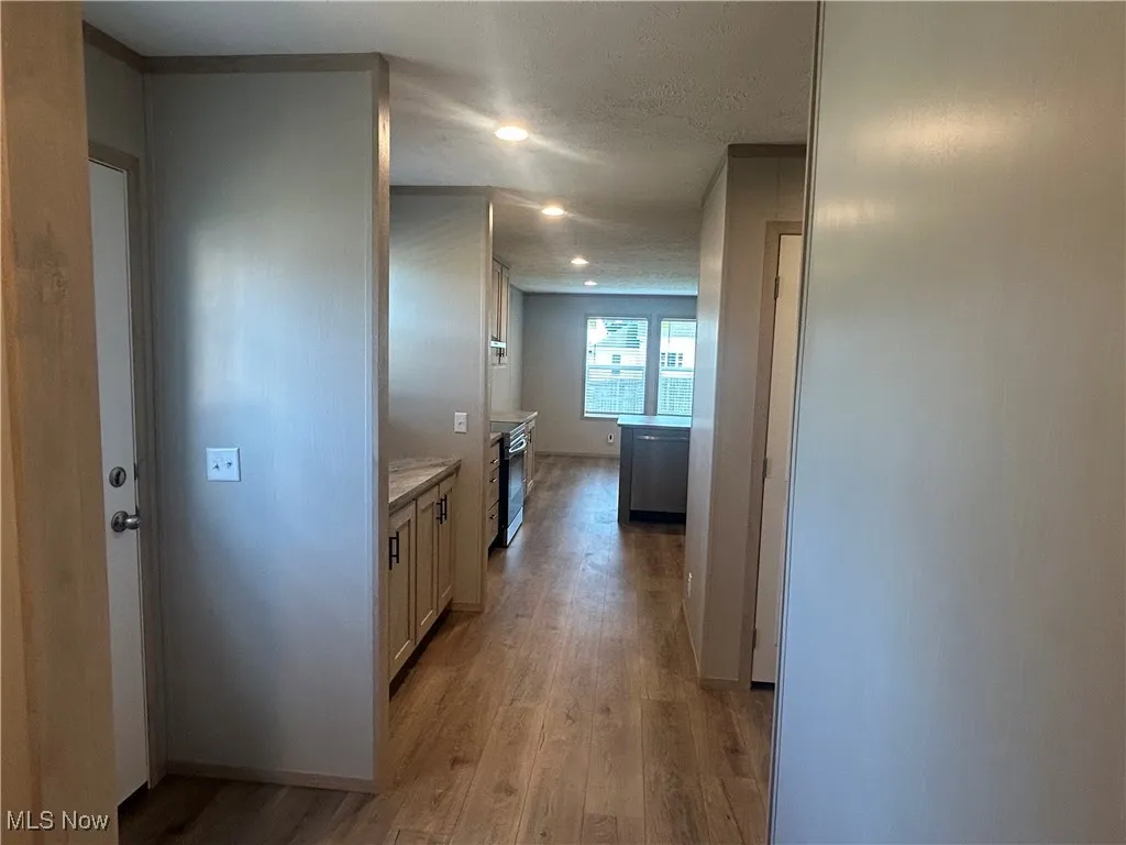 Hallway featuring light wood-style flooring and recessed lighting