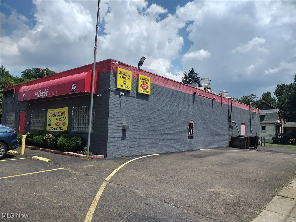 View of building exterior featuring uncovered parking