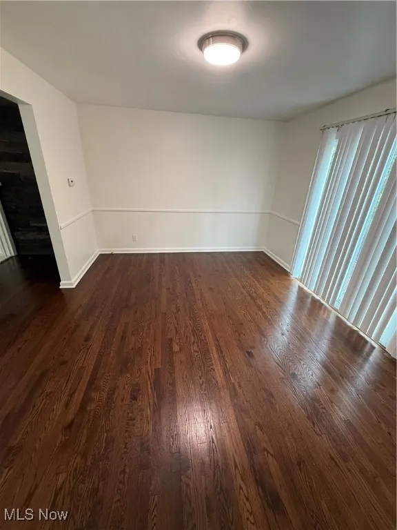 Unfurnished room with dark wood-type flooring