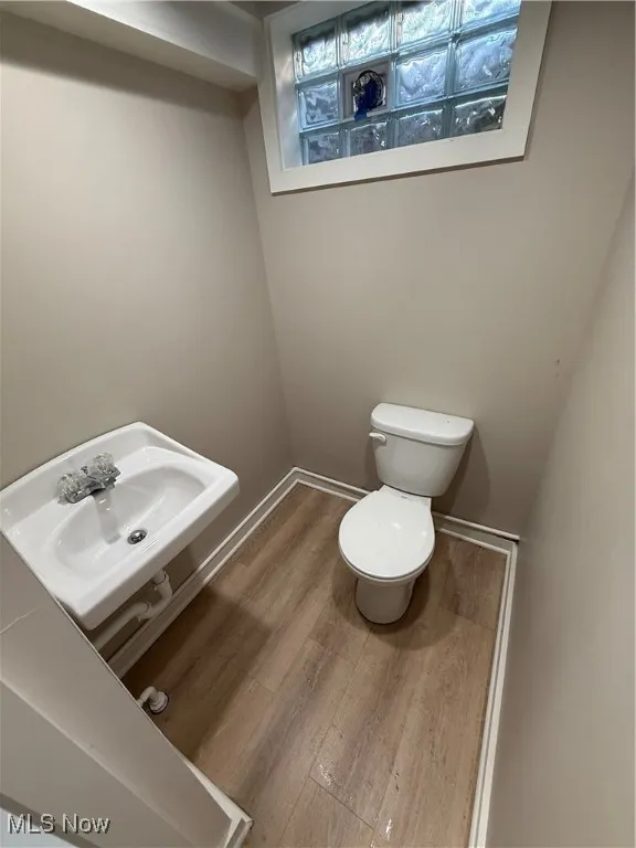 Bathroom with toilet and wood finished floors