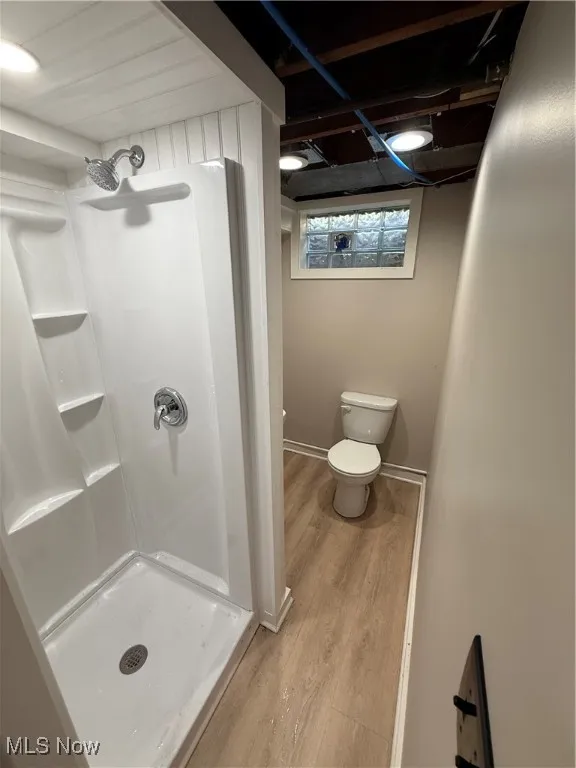 Bathroom featuring wood finished floors and a stall shower