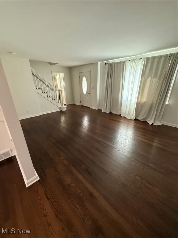 Entryway featuring stairs and dark wood finished floors