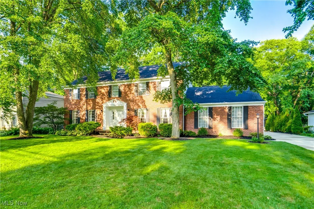 Colonial house with brick siding and a front lawn