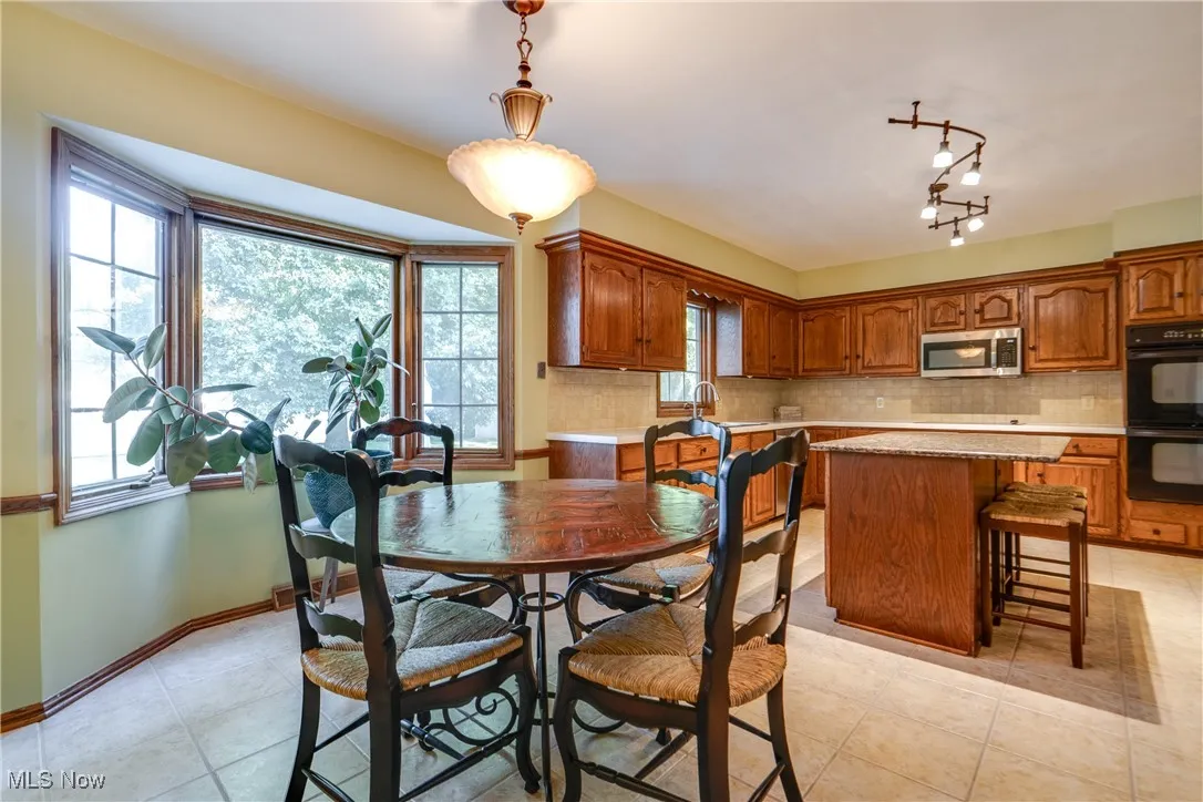 Dining space with light tile patterned floors and baseboards