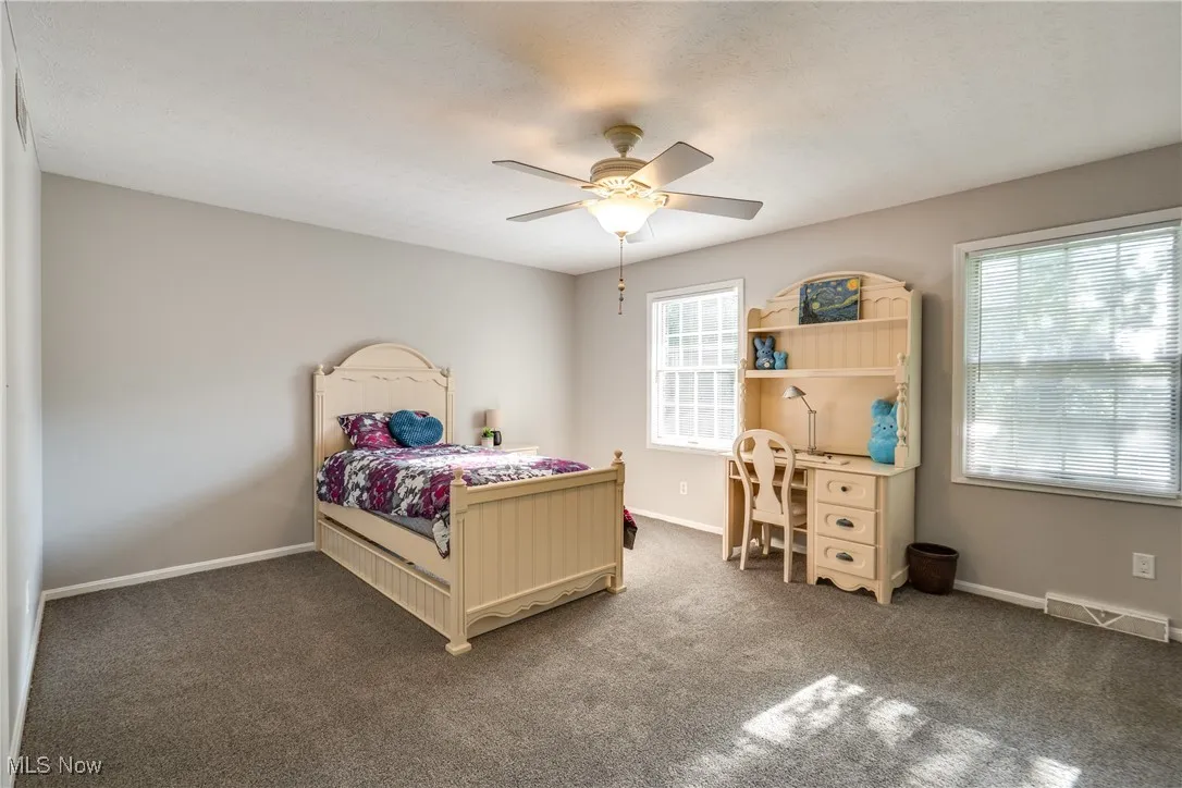 Bedroom featuring dark colored carpet and ceiling fan