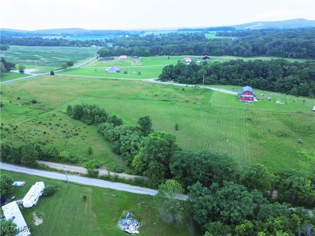 Aerial view of property and surrounding area featuring rural landscape and agricultural land