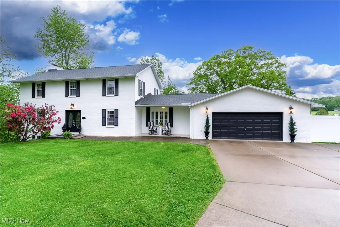 View of front of property with driveway, an attached garage, and brick siding