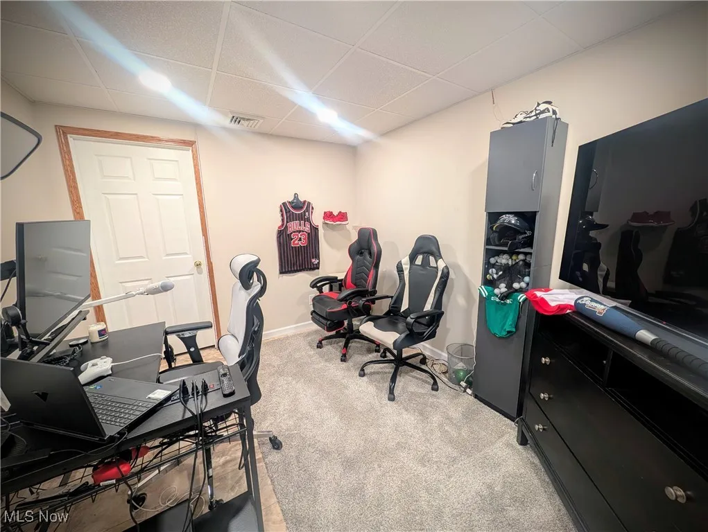 Office area featuring carpet flooring and a drop ceiling