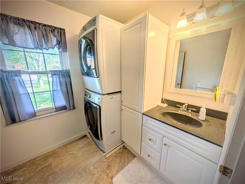 Bathroom featuring stacked washer / dryer and vanity