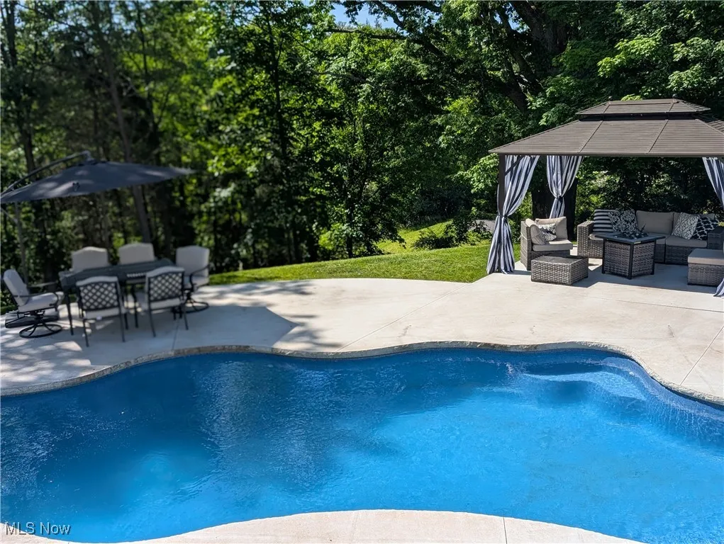 Outdoor pool with outdoor lounge area, a patio, a gazebo, outdoor dining area, and a yard