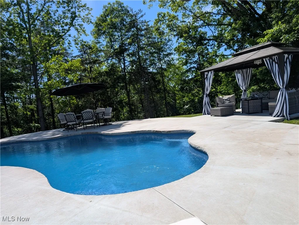Swimming pool featuring a patio area, a gazebo, and outdoor lounge area