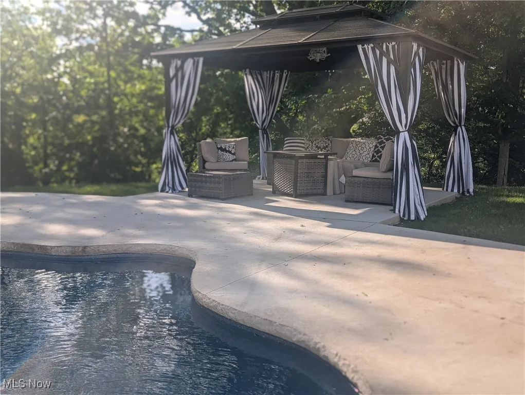 Outdoor pool with a gazebo, outdoor lounge area, and a patio area
