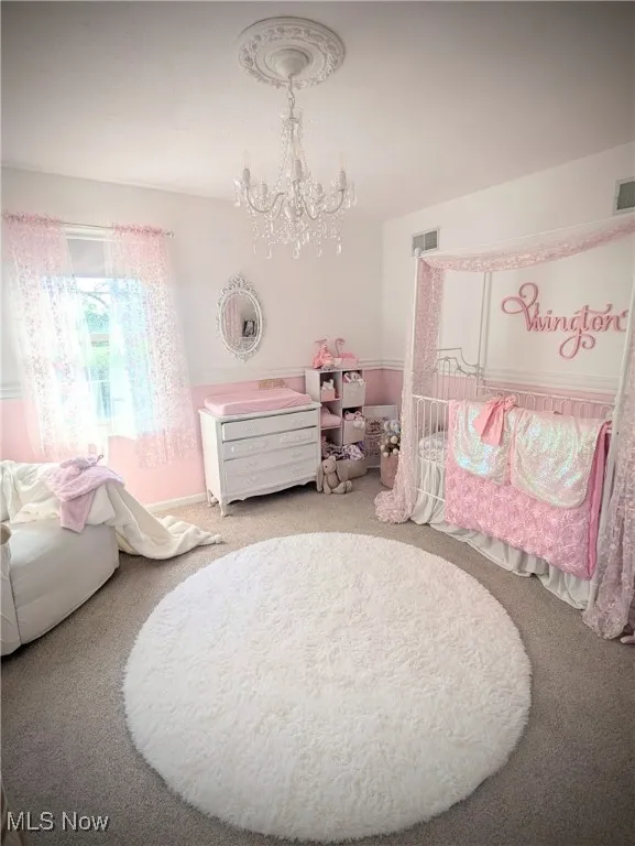 Carpeted bedroom with a chandelier