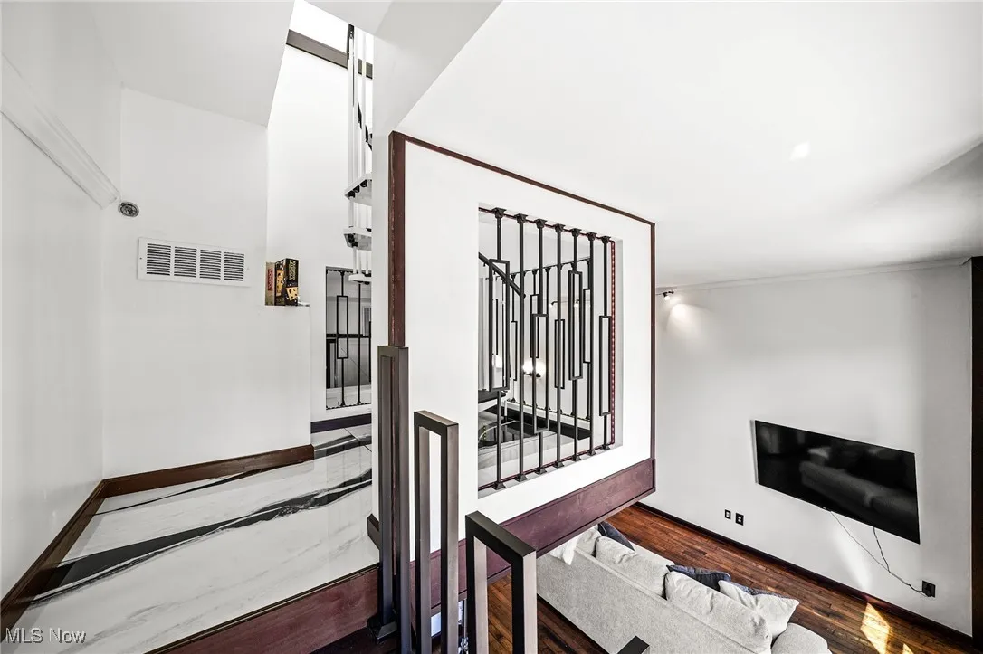 Stairway with wood finished floors and baseboards