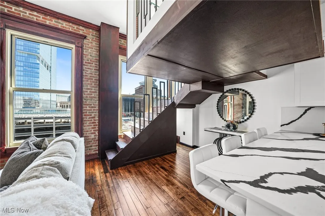 Bedroom featuring wood-type flooring and brick wall