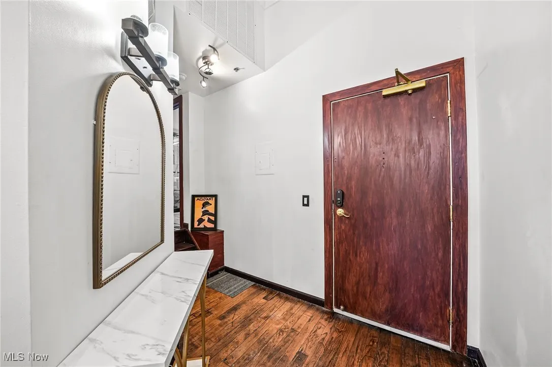 Foyer entrance featuring dark wood finished floors and baseboards