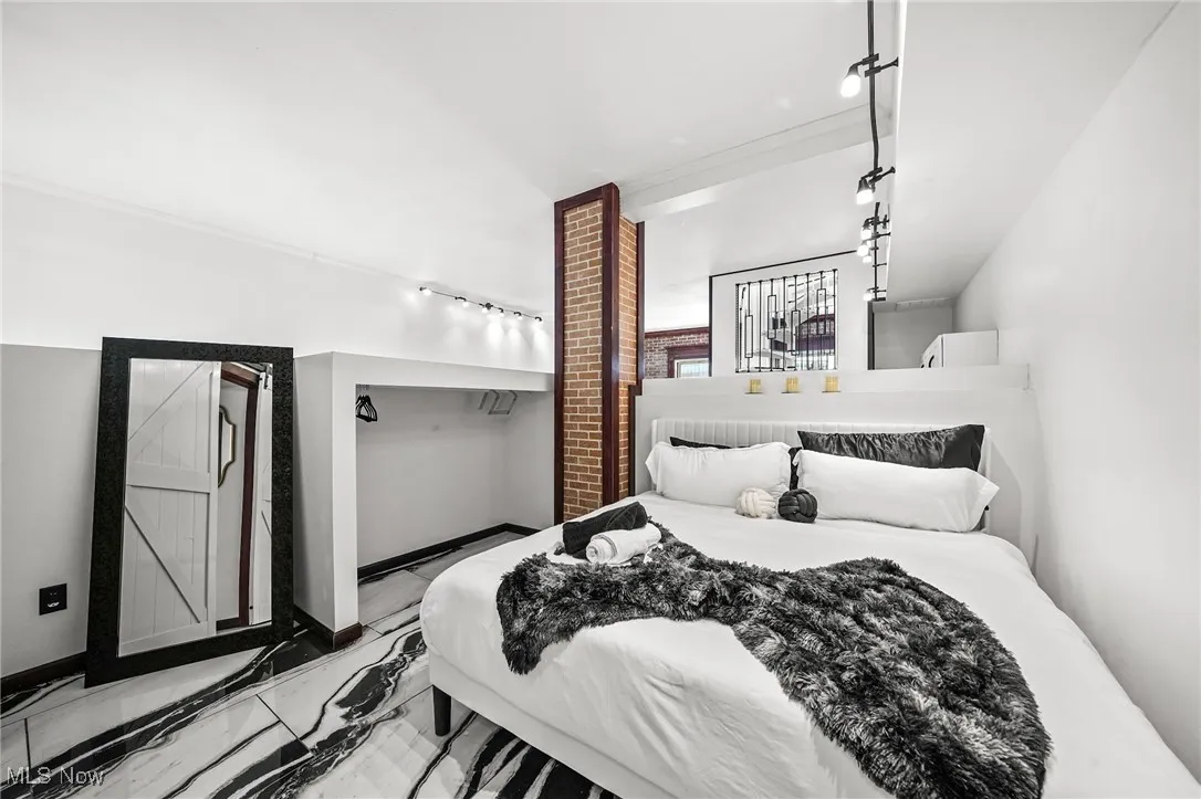 Bedroom with rail lighting and marble finish floors