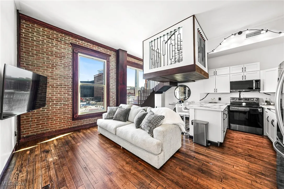 Living area with brick wall and dark wood finished floors