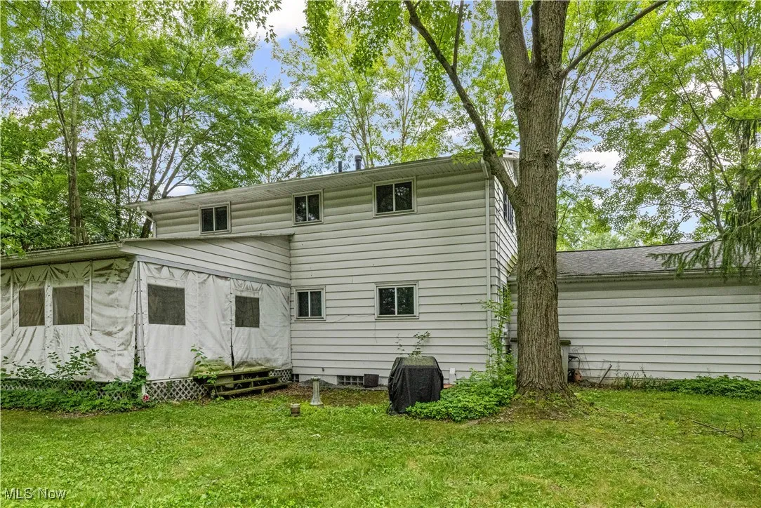 Back of house with a yard and covered porch