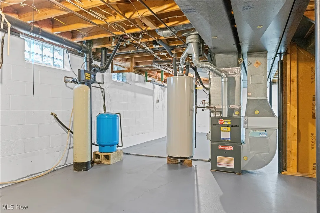 Basement featuring heating unit, water heater, a water softener  and lifetime waterproofing