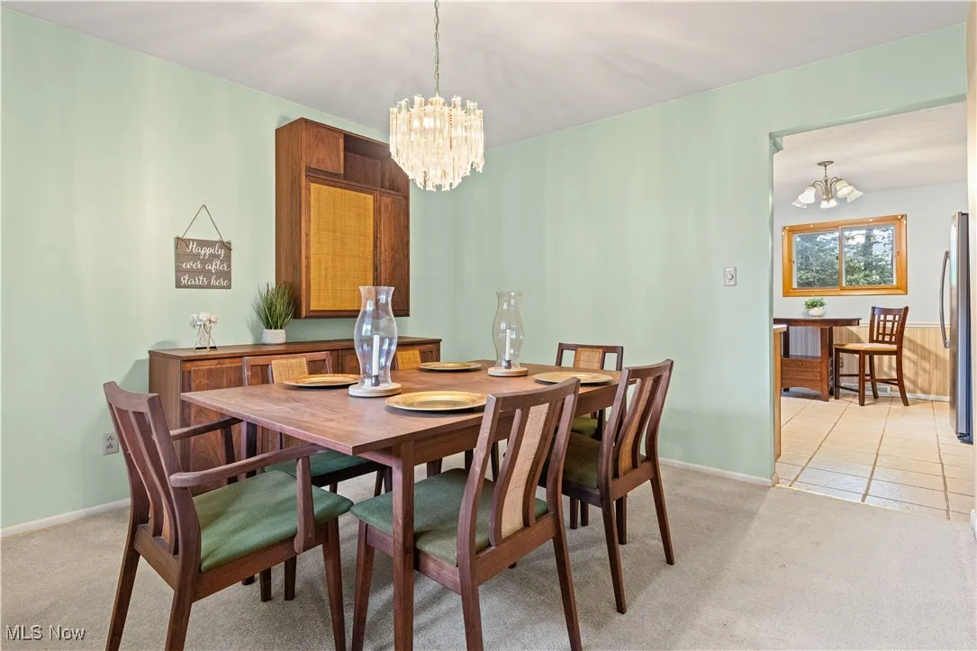 Dining room featuring a chandelier, built-in cabinet and a dining room table to convey.