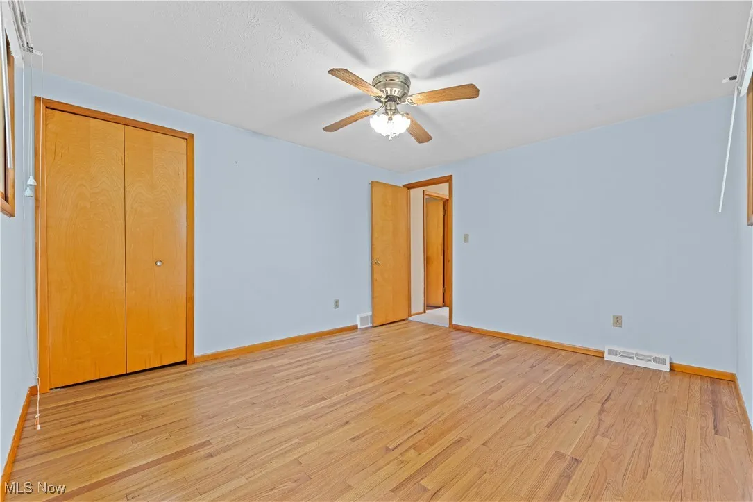 Bedroom with light wood flooring and a ceiling fan