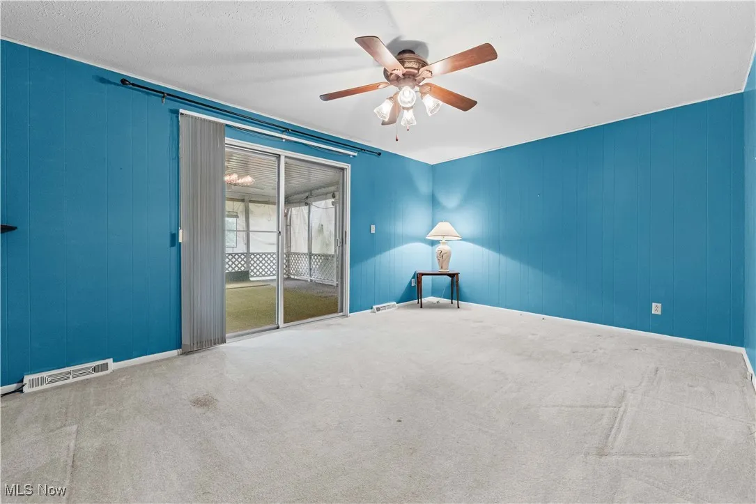 Family room featuring a ceiling fan and entrance to the covered porch